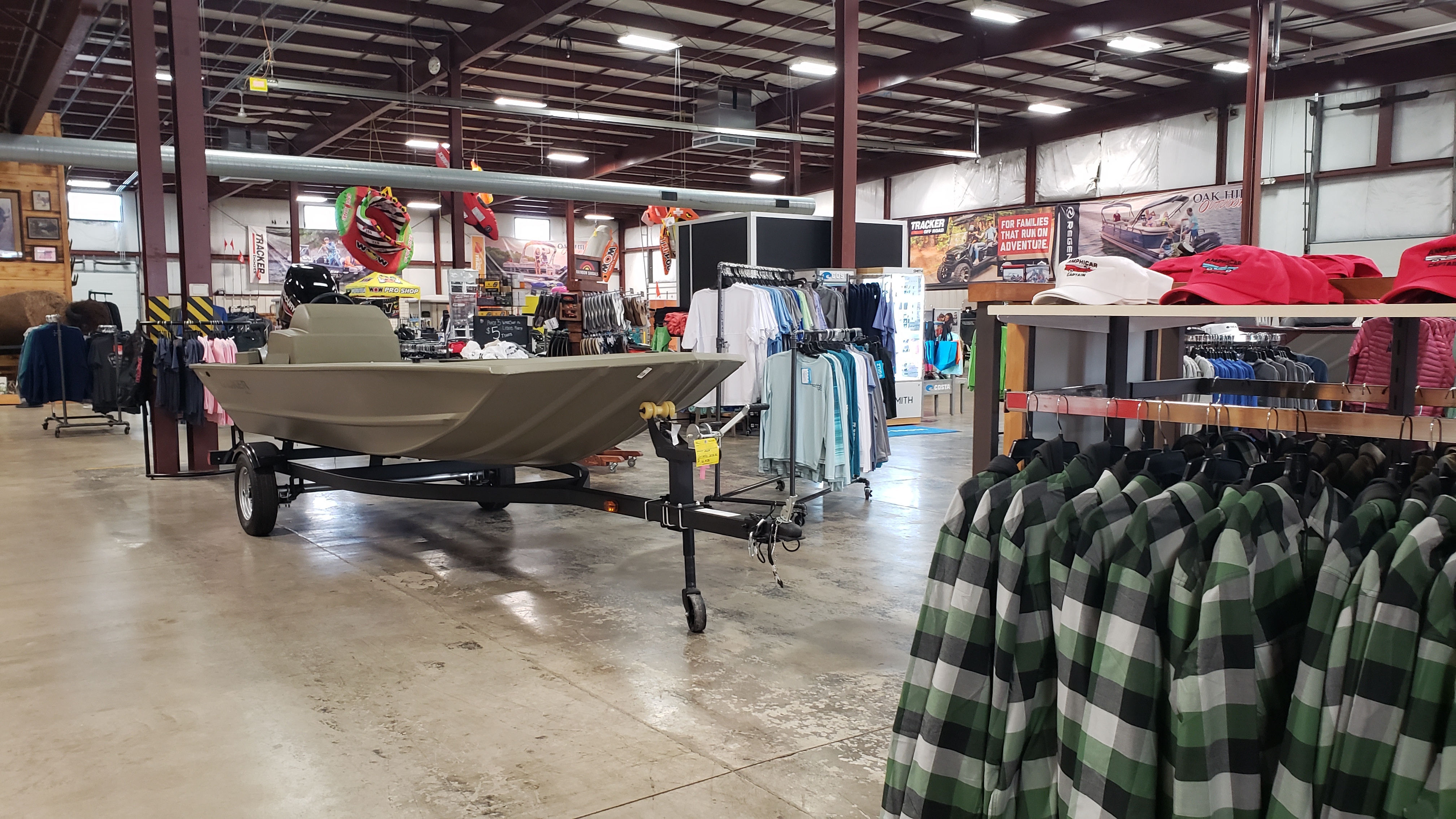 A photo of boats, accessories and garments inside a marine dealership.