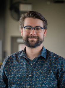 Headshot image of MRAA Data Specialist Drew Mick in a collared blue shirt at Top Golf