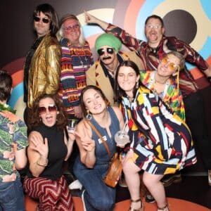 group of people dress in 1970s costumes at event