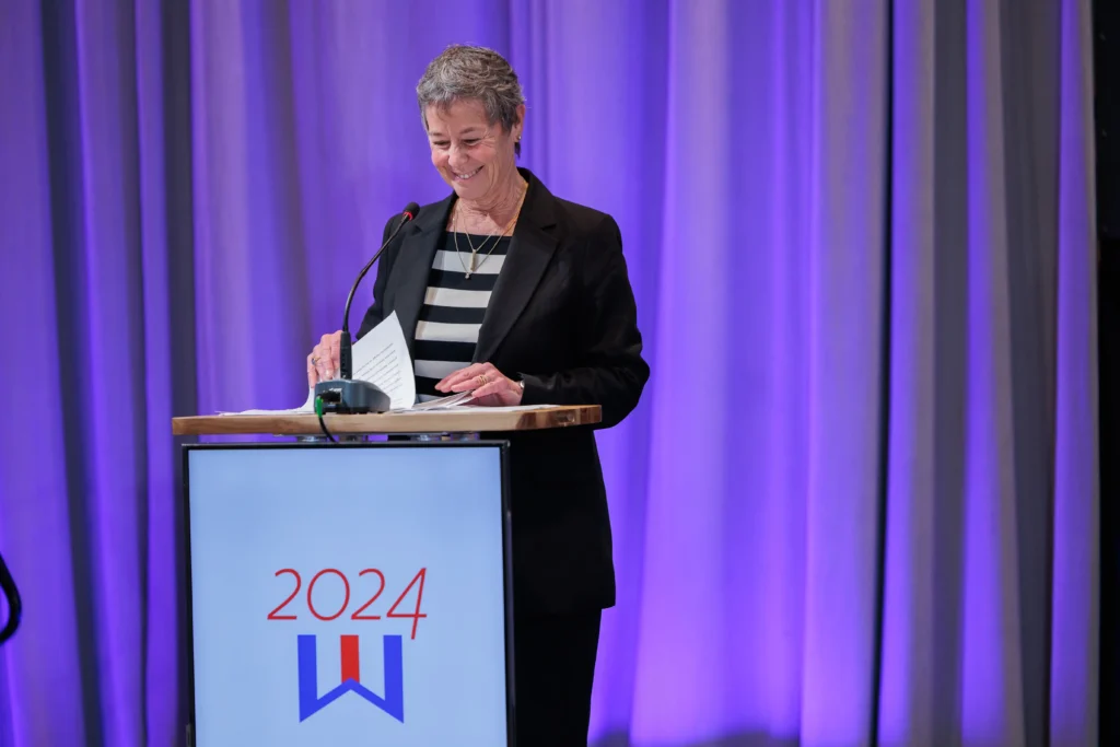 Nancy Cueroni speaks at the podium after receiving the 2024 Darlene Briggs Marine Woman of the Year Award.