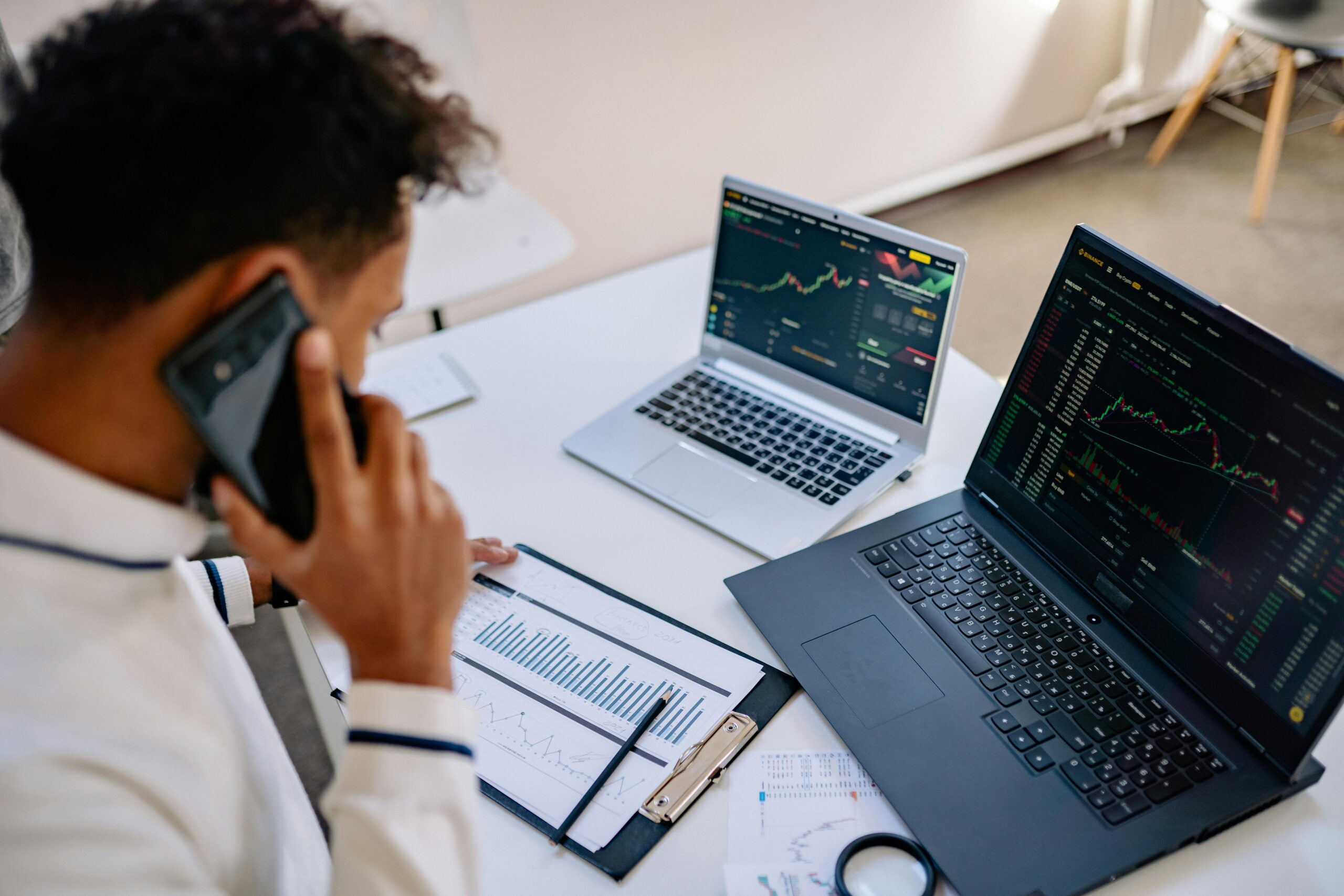 salesperson on phone at desk with data and computers