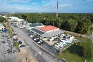 Aerial view of a boat dealership service facility with boats, service bays, and parking areas, representing service efficiency and operational improvement.