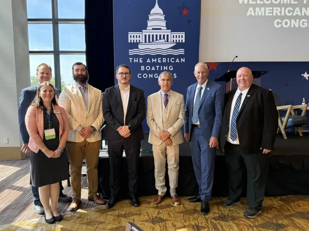 MRAA group photo at American Boating Congress event with branded backdrop and podium.