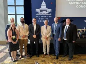 MRAA group photo at American Boating Congress event with branded backdrop and podium.