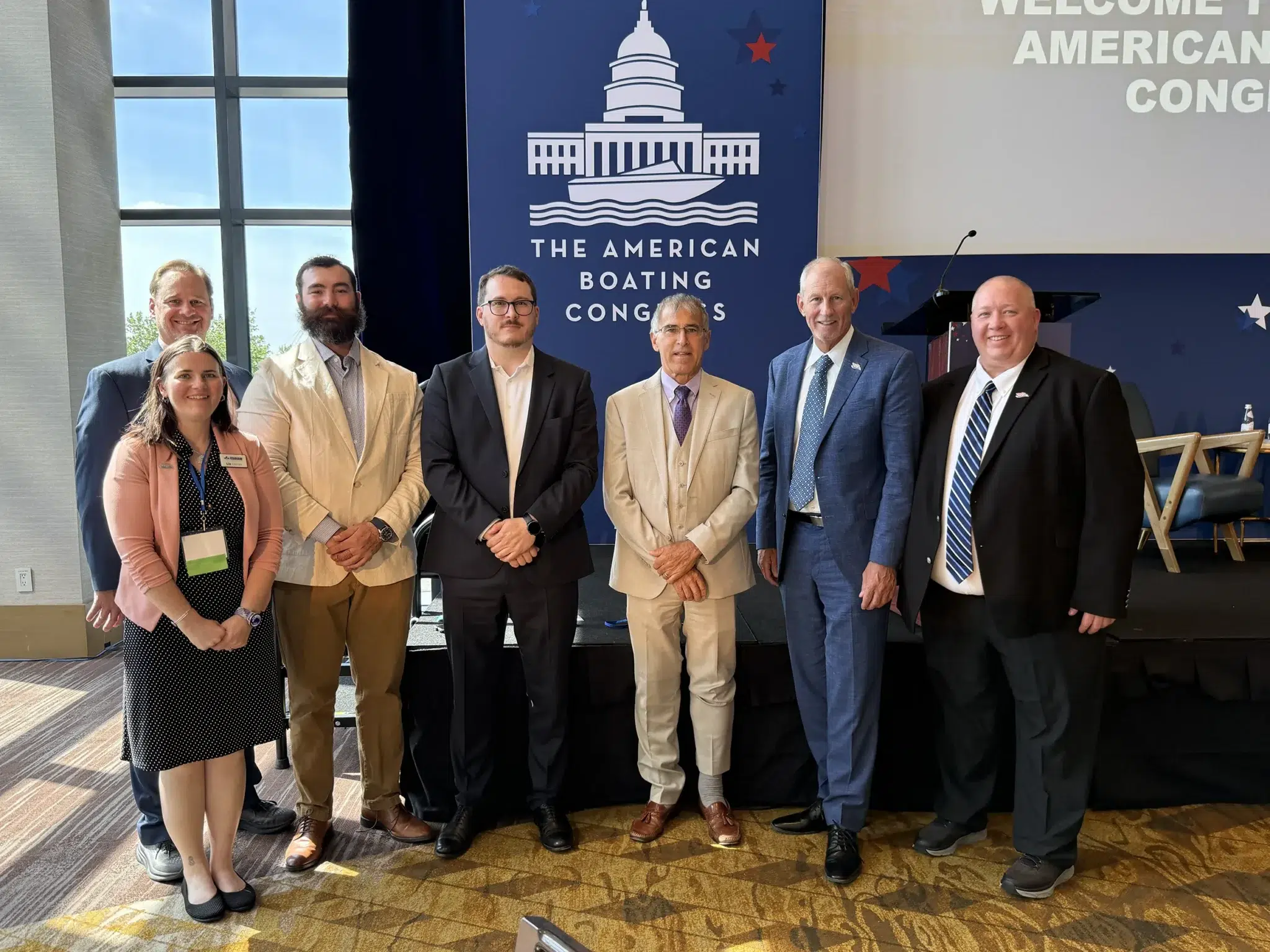MRAA group photo at American Boating Congress event with branded backdrop and podium.