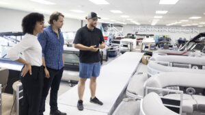 Sales person with shoppers in showroom at boat dealership.